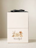 Cream-colored gift box featuring a watercolor autumn floral design and the word thankful, topped with a black ribbon. - Image 