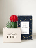 A gift box set featuring a cream-colored box with 'your logo HERE' printed on the front, a small potted red cactus, and a navy blue box with gold string lights pattern and a white 'HAPPY HOLIDAYS' label. - Image 