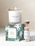 Winter Forest scented candle on a festive teal gift box with a glass jar of luxury matches on a snowy surface. - Image 