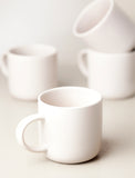 4 ivory ceramic mugs.