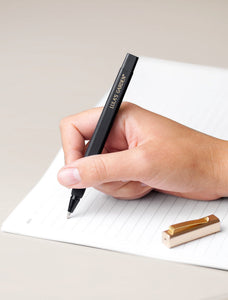 Black pen writing in notebook.