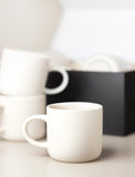 Ivory mugs on table and inside of gift box.