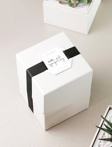 Gift box wrapped in "With Sympathy" top tag.