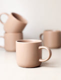 4 tan ceramic mugs.